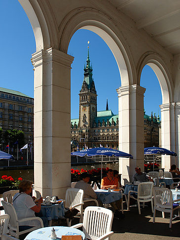 Foto Blick durch die Bögen der Alster Arkaden auf das Rathaus